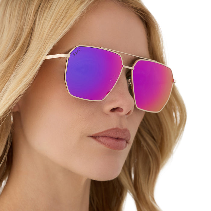 on model - female wearing diff eyewear featuring the berkely navigator sunglasses with a gold frame and pink rush mirror lenses angled view
