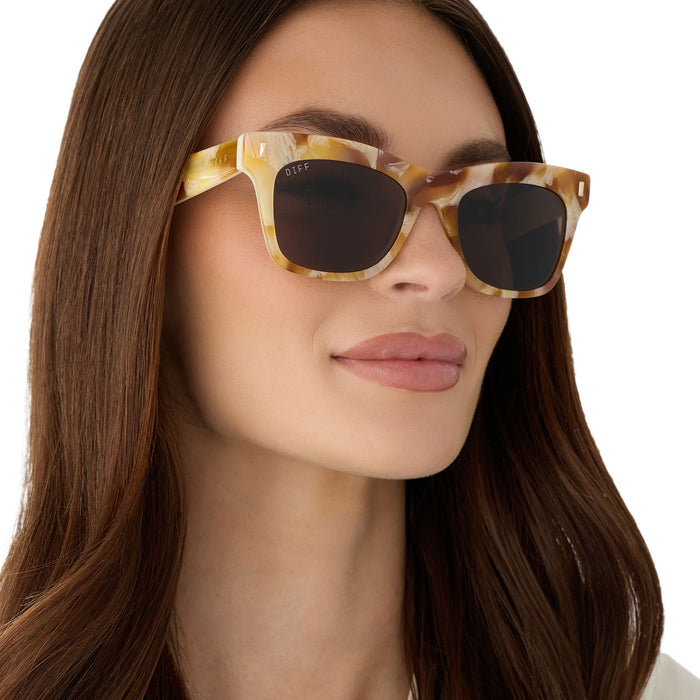on model - female wearing diff eyewear featuring the bradley cateye sunglasses with a gilded tortoise outside and courtside ivory inside acetate frame and brown lenses angled view