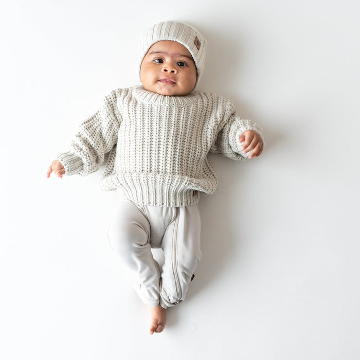Infant wearing soft and stretch Kyte Baby Chunky Knit Ribbed Beanie in Oat neutral