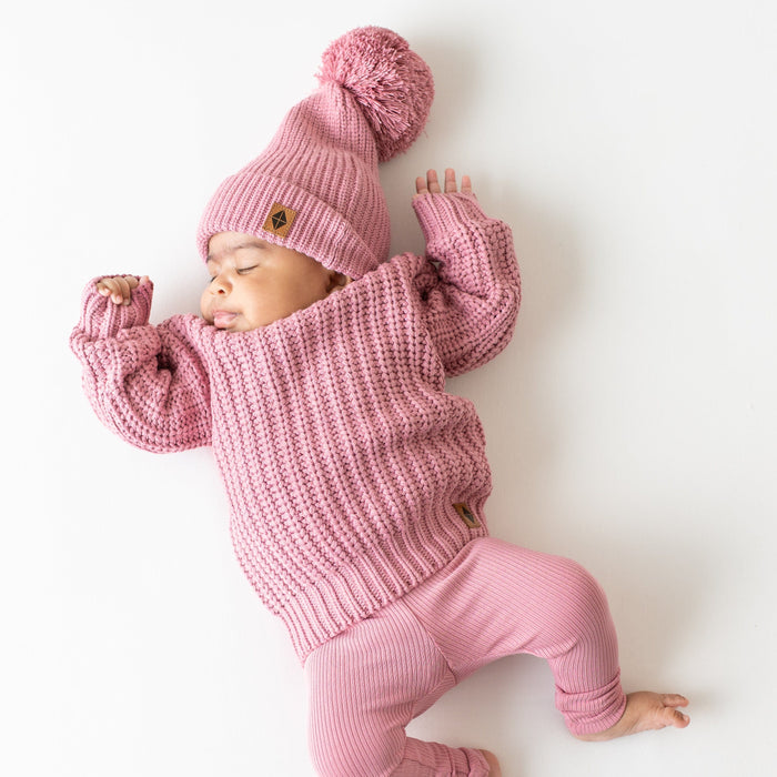 Infant wearing soft and stretchy Kyte Baby Chunky Knit Sweater in Apple Blossom
