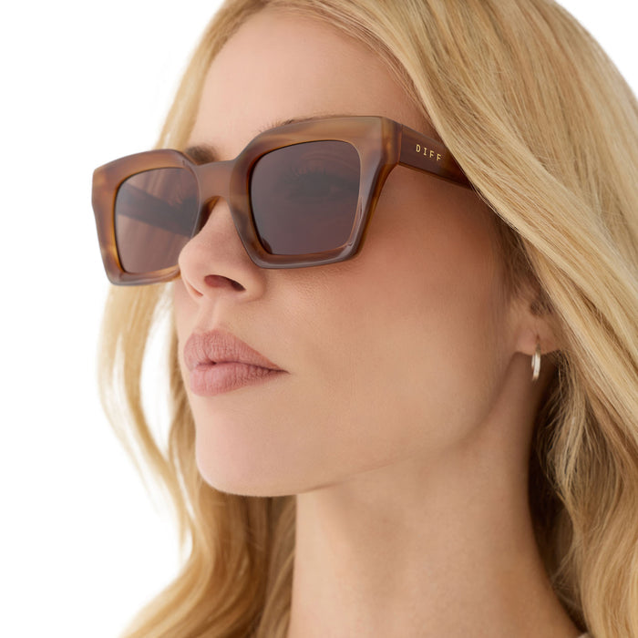 on model - female wearing diff eyewear featuring the greer square sunglasses with a tawny tortoise frame and brown lenses angled view