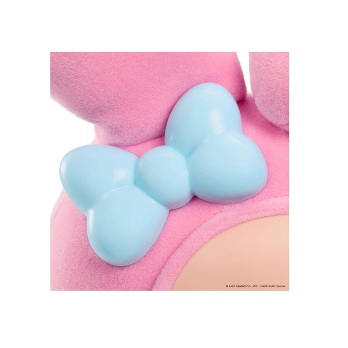 Close-up of a pink plush toy with a blue bow on a white background