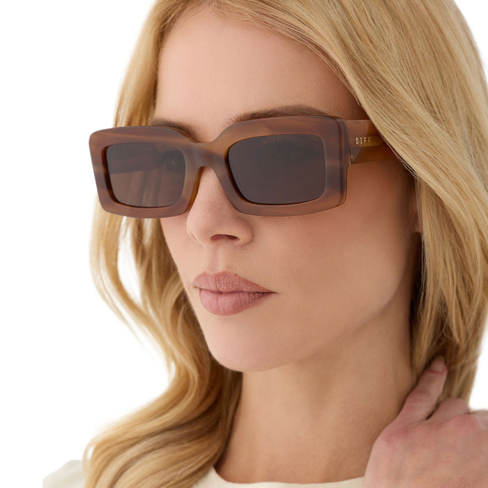 on model - female wearing diff eyewear featuring the indy rectangle sunglasses with a tawny brown tortoise frame and brown polarized lenses angled view
