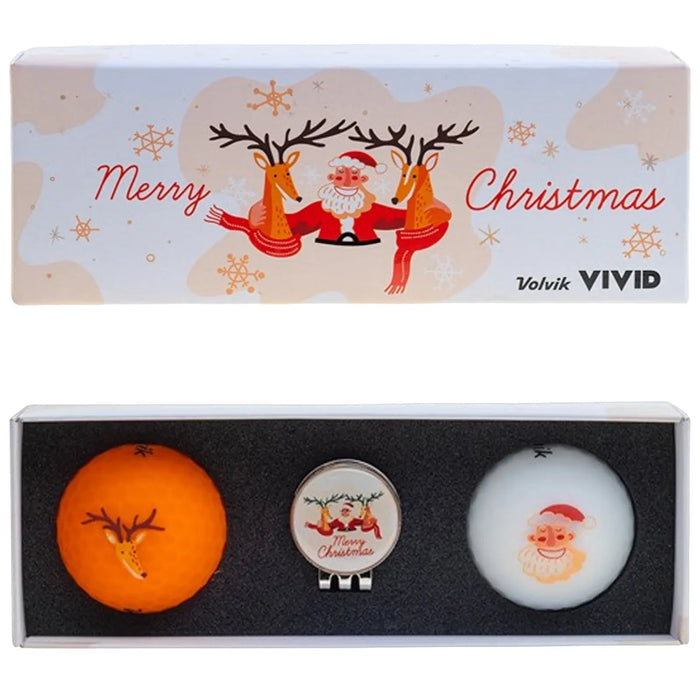 A festive golf ball set includes an orange ball with reindeer designs a white ball featuring a Santa face and a ball marker with a Santa graphic in a decorative box.
