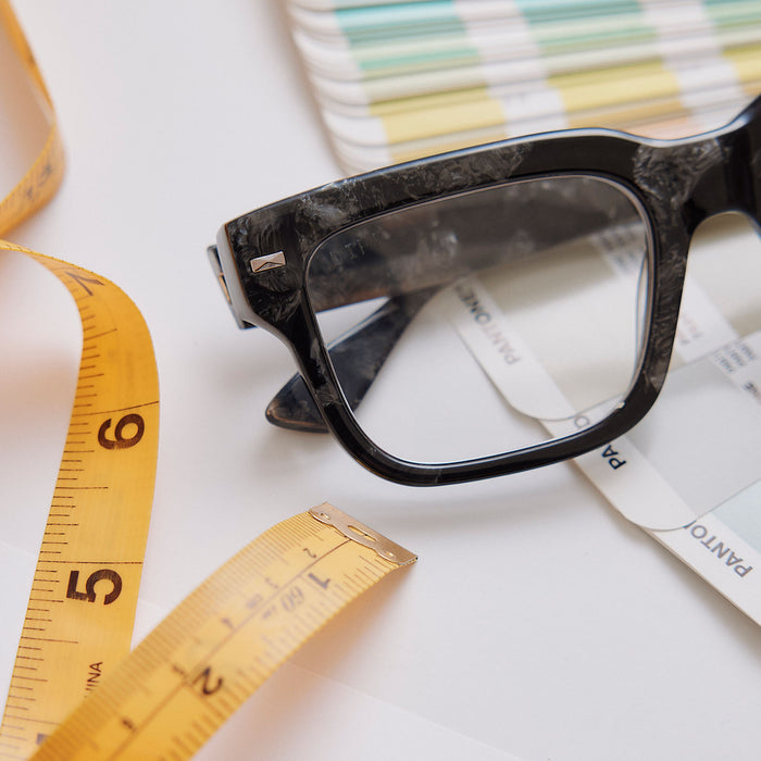 still life of emily in paris x diff eyewear featuring the alfie rectangle prescription glasses with a black tortoise frame detailed close up