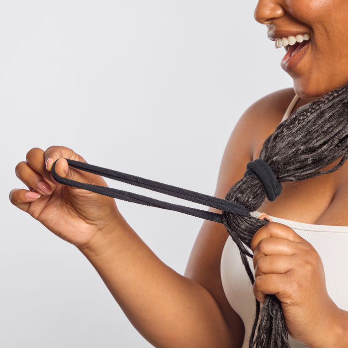 Smiling model with dreadlocks stretching Kitsch Recycled Nylon Thick Elastic in Black