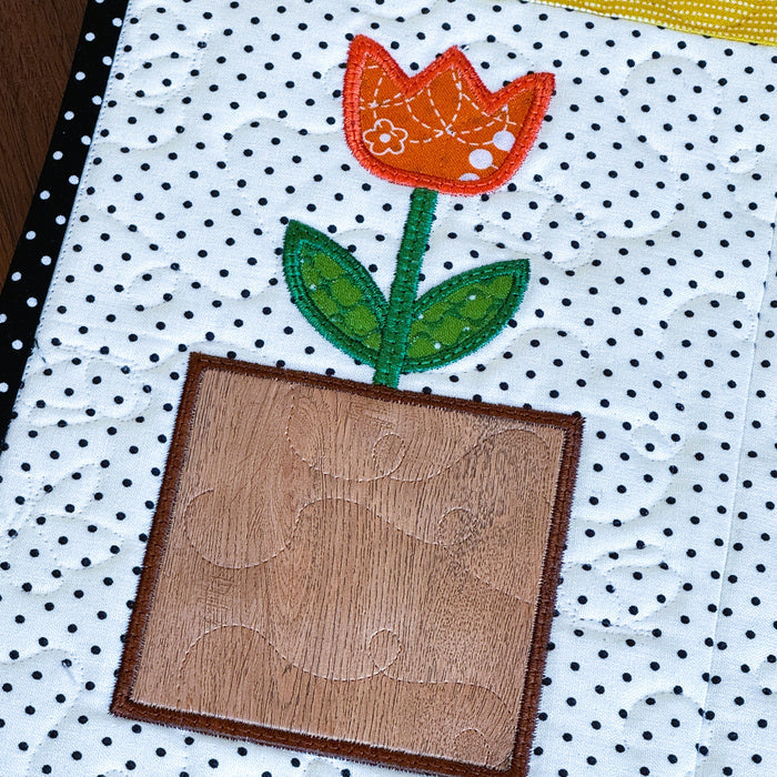 Patchwork quilt with a tulip design on a polka dot background