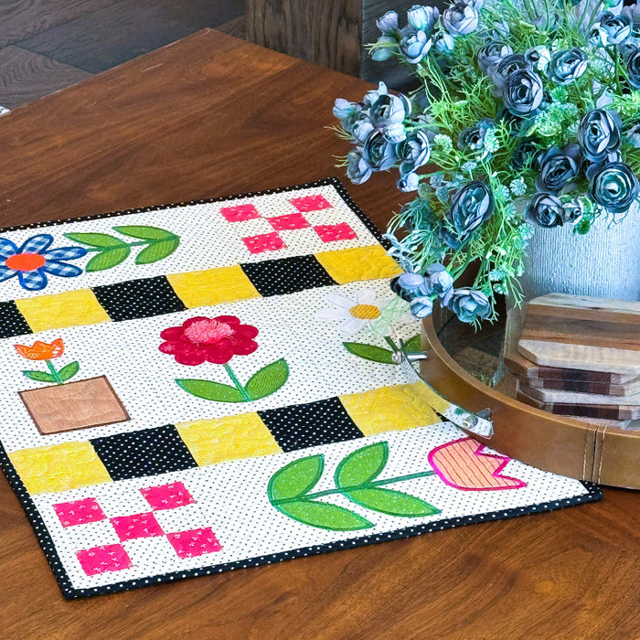 Colorful quilt with floral patterns on a wooden floor