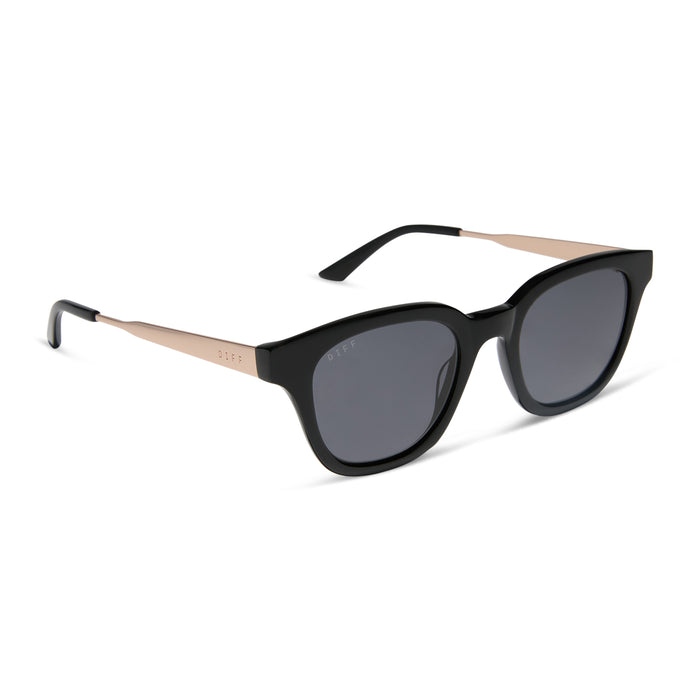 diff eyewear featuring the bridget round sunglasses with a black with gold frame and grey polarized lenses angled view