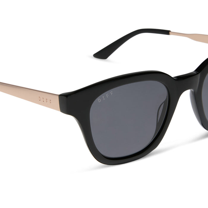 diff eyewear featuring the bridget round sunglasses with a black with gold frame and grey polarized lenses detailed view