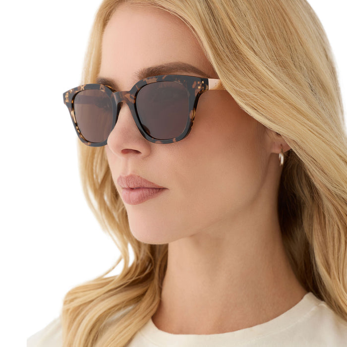 on model - female wearing diff eyewear featuring the bridget round sunglasses with a espresso tortoise frame and brown polarized lenses angled view
