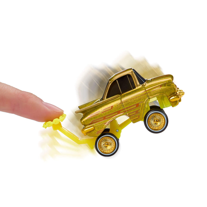 Gold toy truck being pushed by a hand on a white background