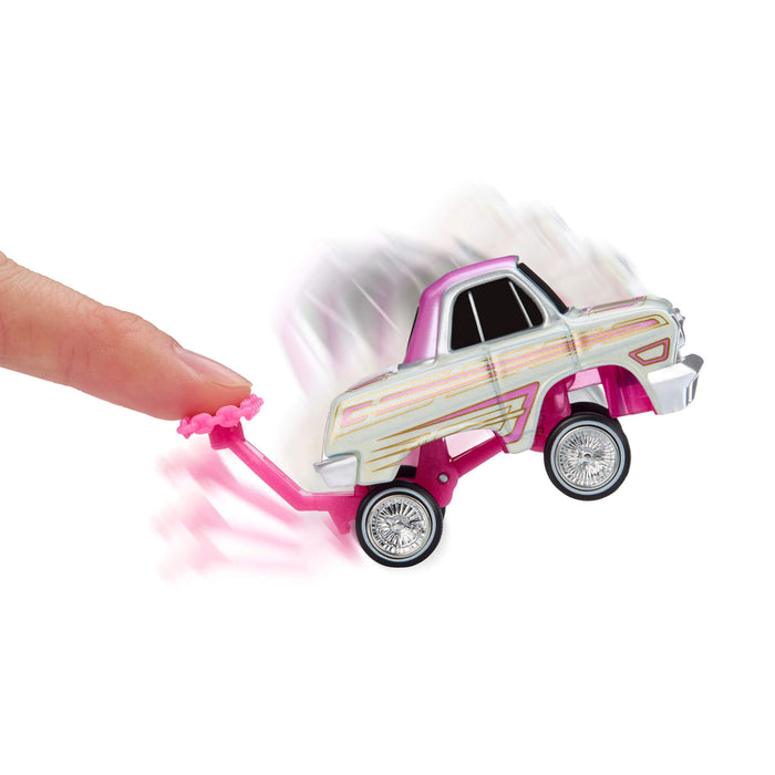 Toy truck with pink handle being pushed by a finger on a white background