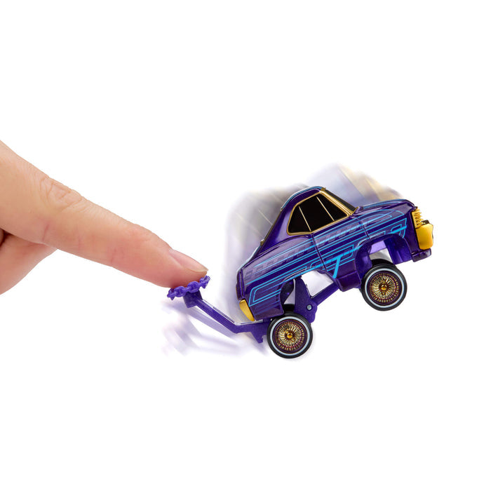 Toy car being pushed by a finger with a purple tool on a white background
