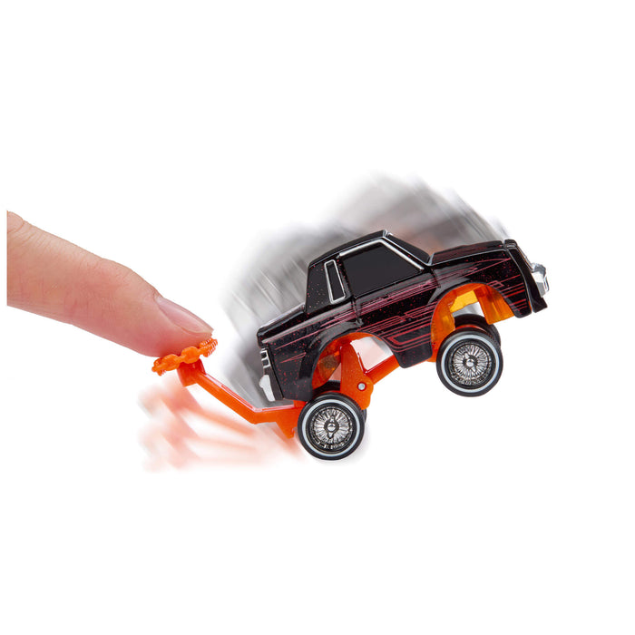 Toy car with a hand pushing on an orange handle against a white background