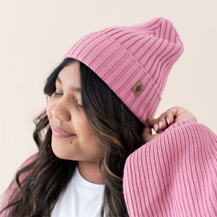 Woman wearing Kyte Baby Chunky Knit Adult Ribbed Beanie in Apple Blossom