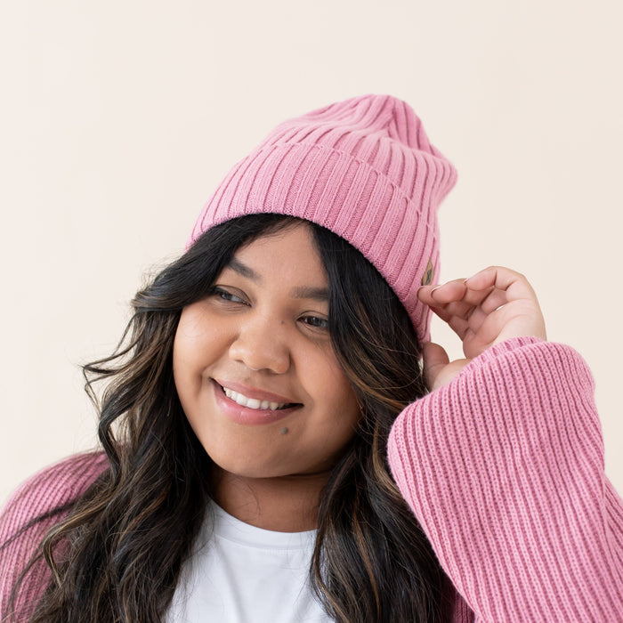 Woman wearing Kyte Baby soft and stretchy Chunky Knit Adult Ribbed Beanie in Apple Blossom