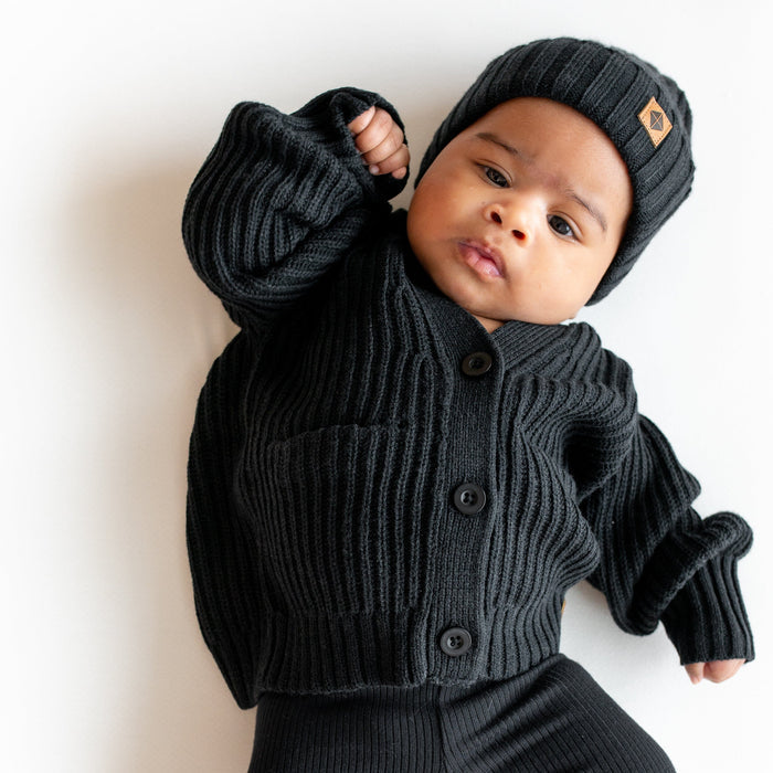 Infant wearing Kyte Baby Chunky Knit Oversized Cardigan and Ribbed Beanie in Midnight