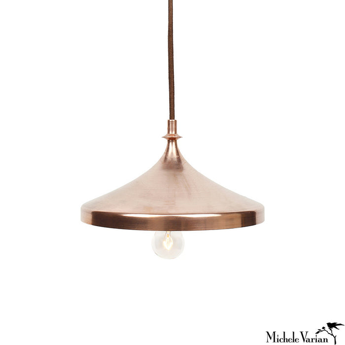 A contemporary copper finial disk pendant light with a visible bulb, suspended by a cord. Designed by Michele Varian.