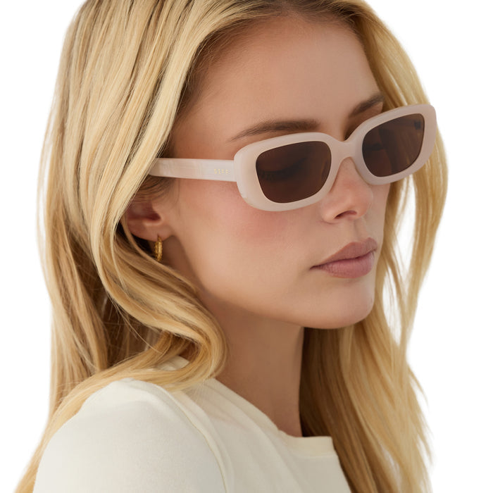 on model - blonde female wearing diff eyewear daphne ii rectangle sunglasses with a milky blush acetate frame and brown polarized lenses detailed view