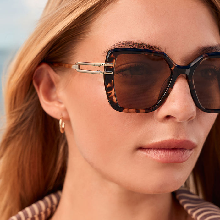 lifestyle -female at the beach wearing diff eyewear featuring the dasha square sunglasses with a espresso tortoise with gold frame and brown polarized lenses detailed view
