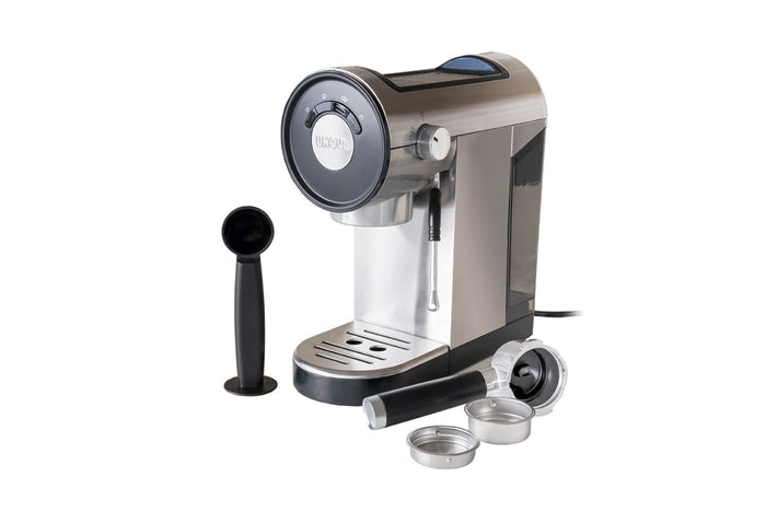 Die Unold Espressomaschine Piccopresso umfasst einen Siebträger, zwei Metallfilterkörbe und einen schwarzen Kaffeelöffel/Stampfer, alles auf weißem Hintergrund.