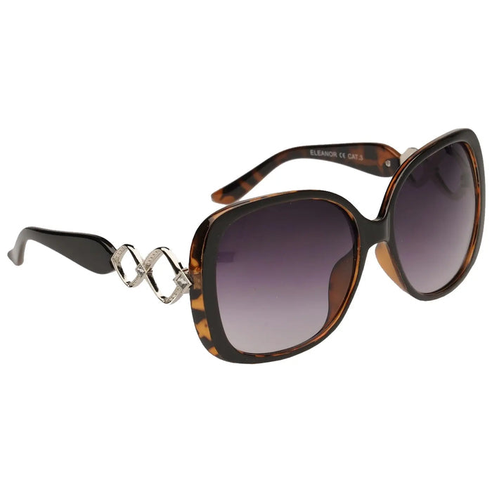 Oversized tortoiseshell sunglasses with dark gradient lenses feature decorative silver elements on the frame and are presented against a neutral background, emphasizing their stylish design.