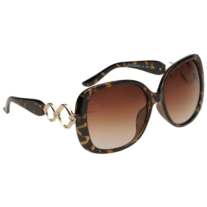 Black and brown tortoiseshell sunglasses are prominently displayed featuring oversized lenses and decorative gold accents in a diamond pattern on the temples against a neutral background