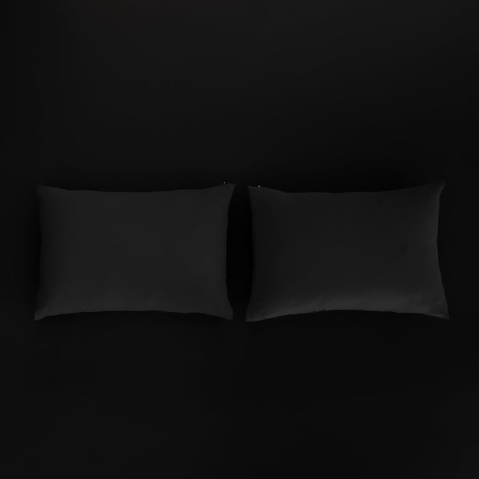 Kyte Baby Pillowcases in Midnight sitting on fitted sheet