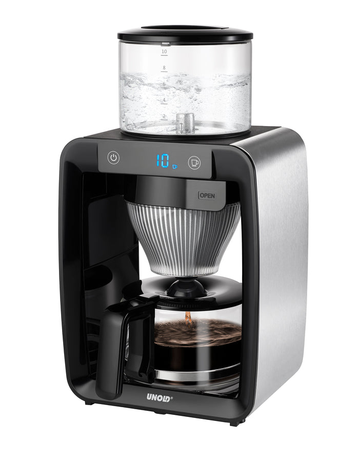 Das Unold Frühstücks-Bundle Aroma ist eine moderne elektrische Kaffeemaschine mit silber-schwarzem Finish, transparentem Wassertank oben, digitaler Anzeige und Glaskanne für gebrühten Kaffee.