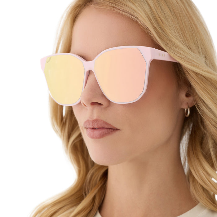 on model - female wearing diff eyewear featuring the gia square sunglasses with a powder pink frame and cherry blossom mirror lenses detailed view