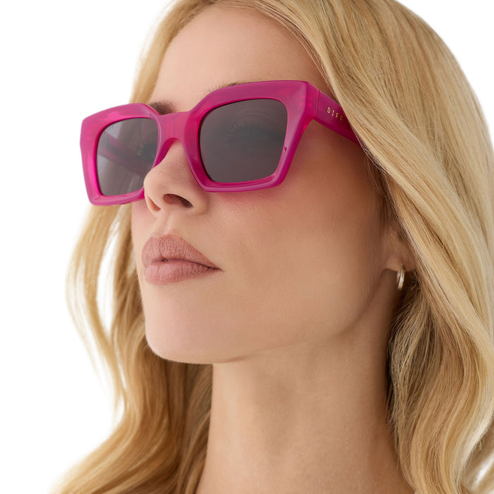 on model - female wearing diff eyewear featuring the greer square sunglasses with a bright tulip pink frame and grey lenses angled view