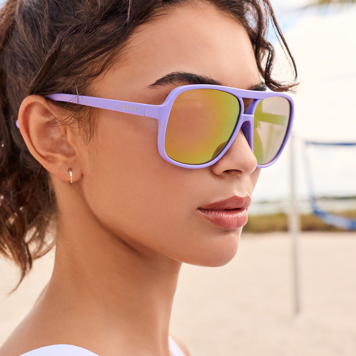 lifestyle - female playing beach volley wearing diff sport hangtime aviator sunglasses with a matte lavender frame and sherbet mirror polarized lenses close up