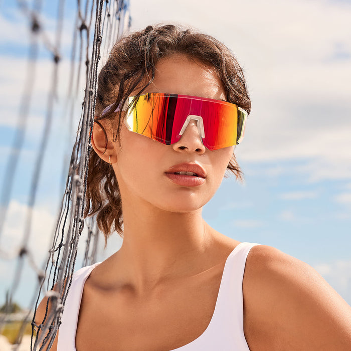 lifestyle - female playing beach volleyball with diff sport heat shield sunglasses with a crystal clear frame and rainbow mirror polarized lenses