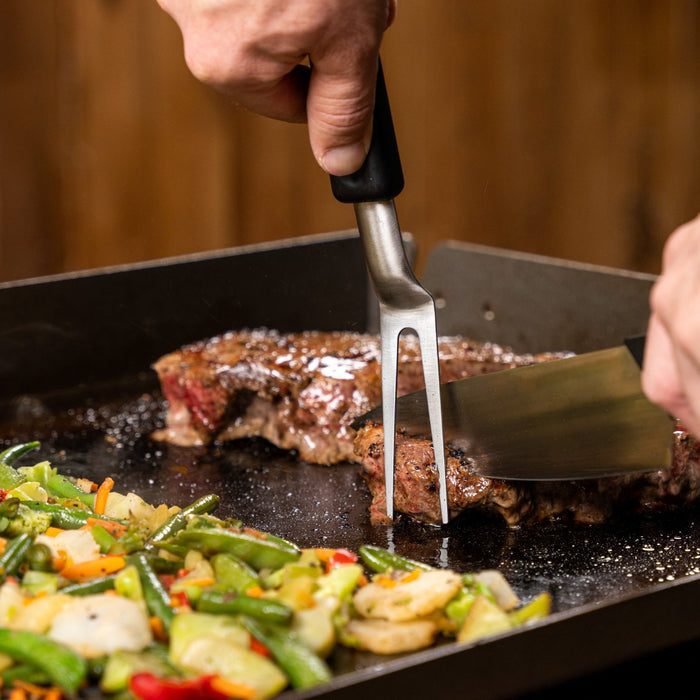 Use the carving fork and knife to cut meal directly on the griddle.