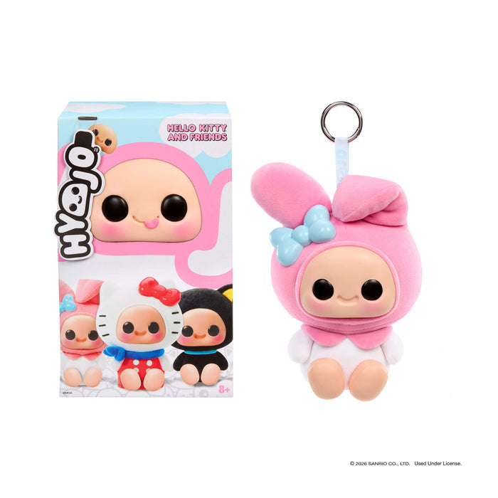 Pink plush keychain with a bow next to its packaging on a white background