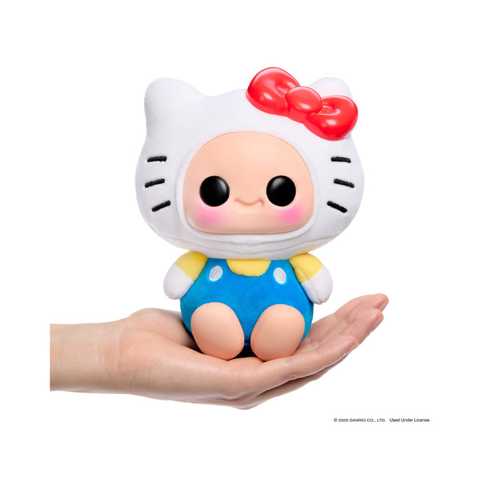 Hello Kitty with a red bow and blue polka dot outfit held in a hand against a white background.