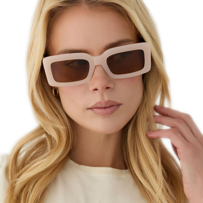 on model - female wearing diff eyewear featuring the indy rectangle sunglasses with a milky blush acetate frame and brown polarized lenses front view