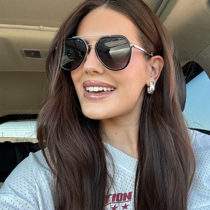 lifestyle - abigail herring brunette with sports jersey shirt wearing black aviators