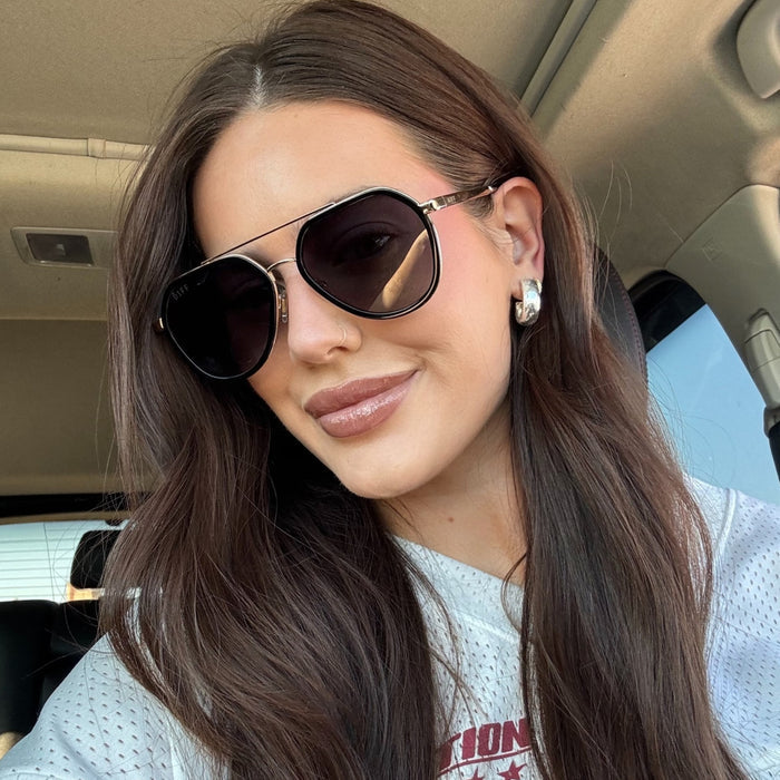 lifestyle - abigail herring brunette with sports jersey shirt wearing black aviators
