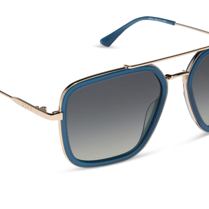 diff eyewear featuring the jordan navigator sunglasses with a clubhouse blue frame and gold metal with grey gradient polarized lenses detailed view