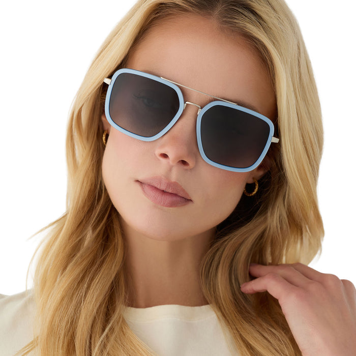 on model - female wearing diff eyewear featuring the jordan navigator sunglasses with a light blue and silver frame with grey gradient polarized lenses front view