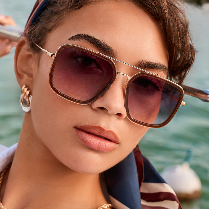 lifestyle - female on the ocean wearing diff eyewear featuring the jordan navigator sunglasses with a whiskey with gold frame and grey gradient lenses front view