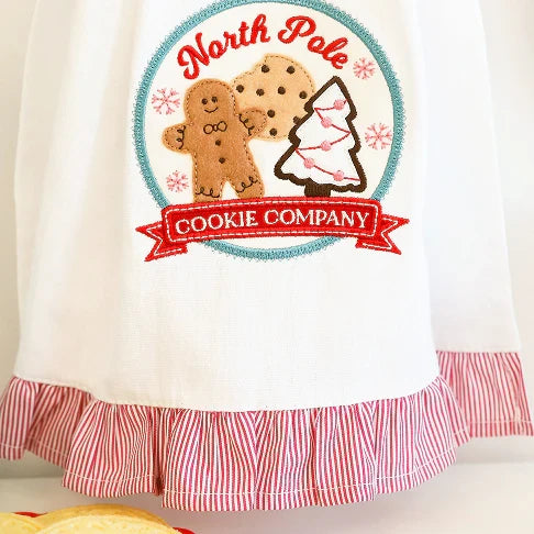 Towel with 'North Pole Cookie Company' design featuring gingerbread men and a cookie cutter.