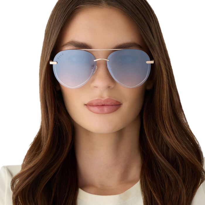 on model - female wearing diff eyewear featuring the lenox xs aviator sunglasses with a champagne gold (light gold) frame and blue slate gradient with silver flash lenses front view
