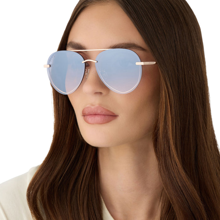 on model - female wearing diff eyewear featuring the lenox xs aviator sunglasses with a champagne gold (light gold) frame and blue slate gradient with silver flash lenses detailed view
