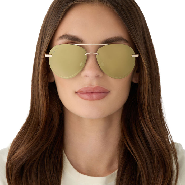 on model - female wearing diff eyewear featuring the lenox xs aviator sunglasses with a gold metal frame and aloe green gradient with light gold flash polarized lenses front view