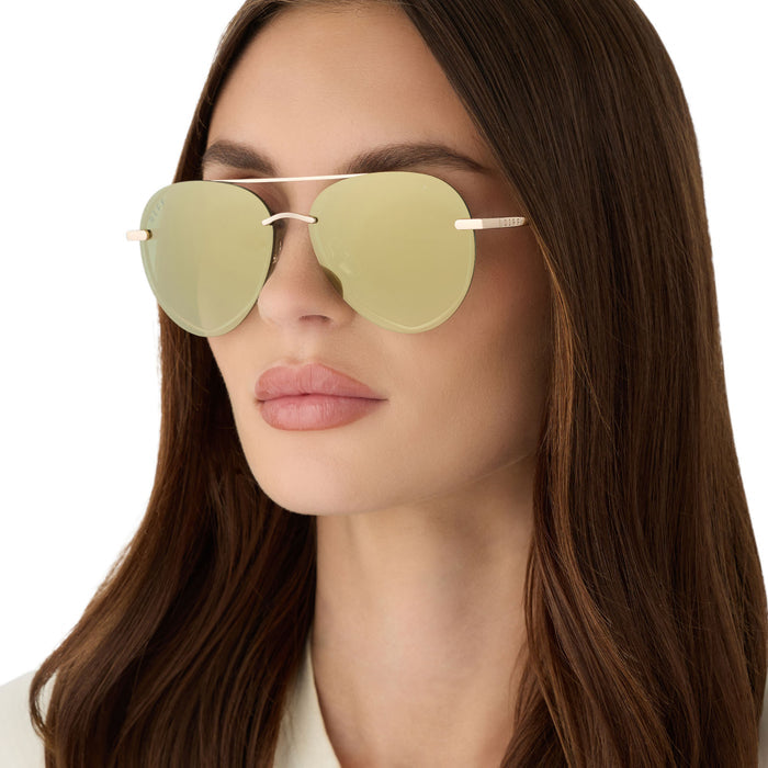 on model - female wearing diff eyewear featuring the lenox xs aviator sunglasses with a gold metal frame and aloe green gradient with light gold flash polarized lenses angled view