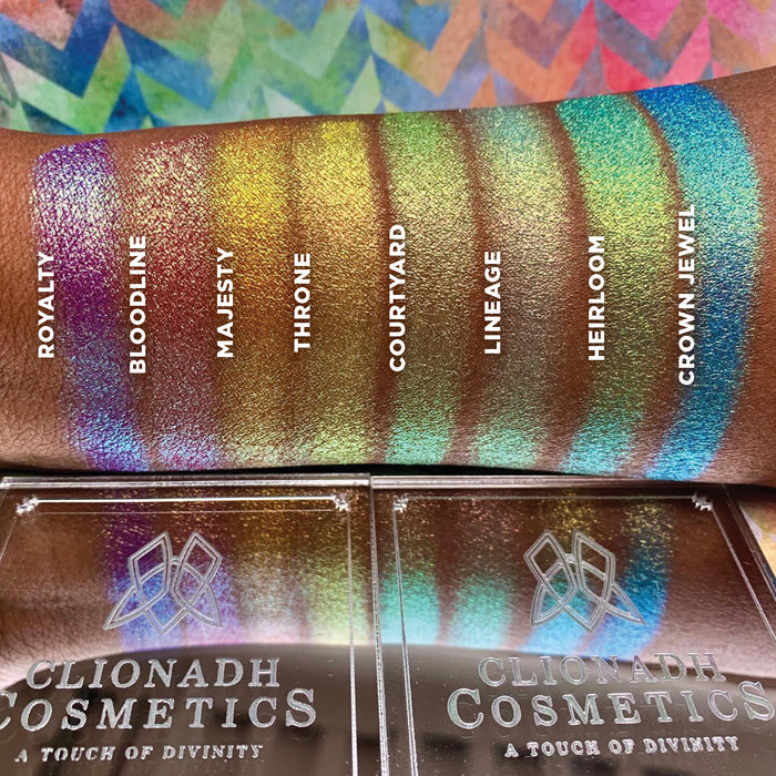 Top angled arm swatches on deep skin tone of Lineage Vibrant Multichrome Eyeshadow shifts next to Crown Jewel, Heirloom, Courtyard, Throne, Majesty, Bloodline, Royalty