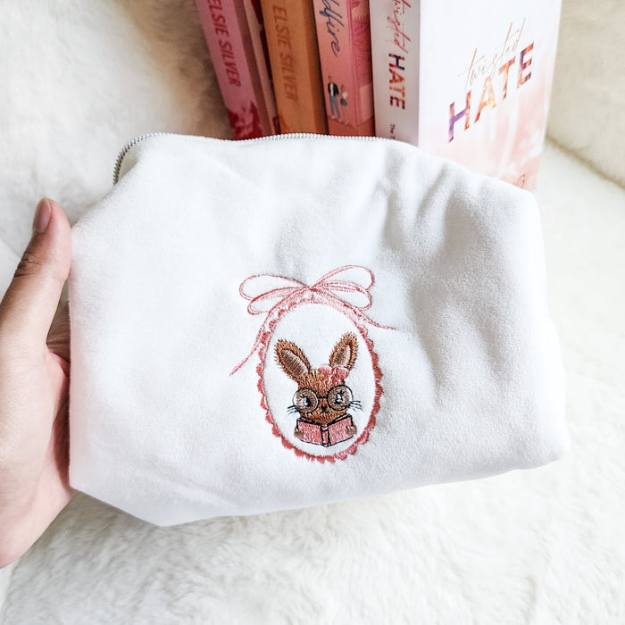 Little Rabbit and Her Book Zippered Pouch | Bookish Makeup & Reading Accessories Bag - The Bean Workshop - book girlie, bookish gift, bookish pouch, bow, coquette, coquette aesthetic, embroidered pouch, gift for book lovers, kindle bag, makeup bag, quilted pouch, rabbit book bag, reading accessories, reading accessories bag, zipper pouch
